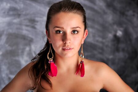 Young woman portrait with long red earringsの写真素材