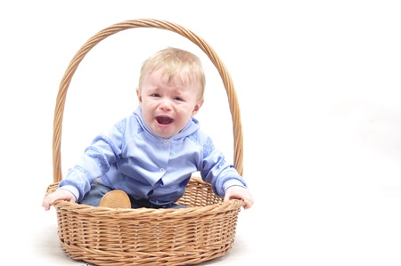 Baby boy crying in basket on white backgroundの写真素材