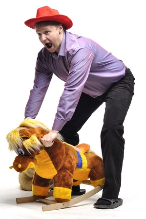 Adult man tomfoolery with a children toyの写真素材
