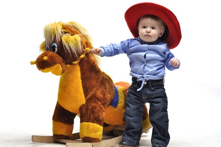 Baby in cowboy style stay before toy horseの写真素材