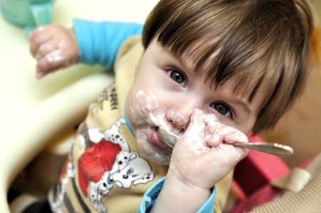 Baby tries to eat independentlyの写真素材
