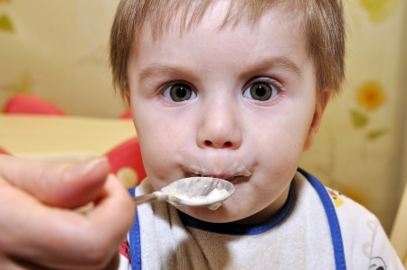 Cute baby eat porridgeの写真素材
