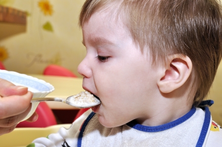 Cute baby eat porridgeの写真素材