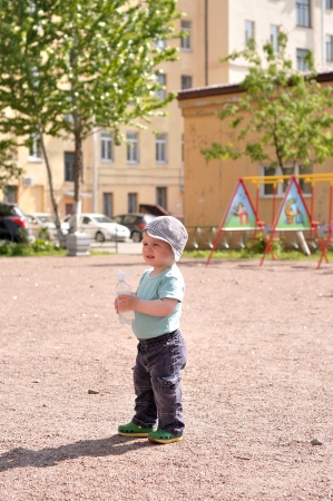Little boy stand with a water bottleの写真素材