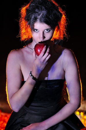 Halloween looking witch in a dark with appleの写真素材