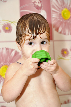 Portrait baby in bathroom with toy in handsの写真素材