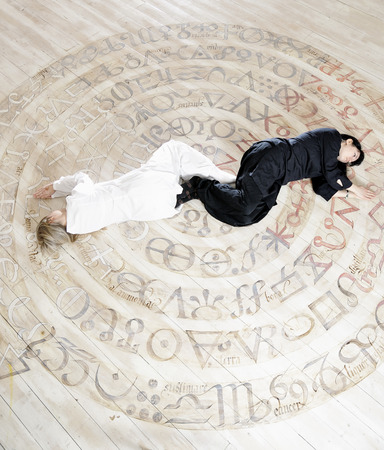 Two young woman in balsck and white dress relaxing with yoga styleの写真素材