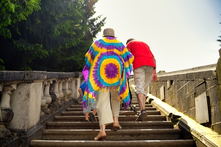 Grandmother, grandfather and grandson walk upstairs with stollerの写真素材