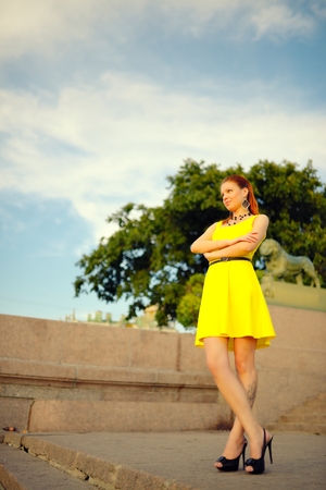 Portrait of the beautiful woman in a yellow dress on in Sankt Petersburg at sunsetの写真素材
