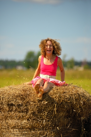 Sexy fashion woman in red dress jumps on haystackの写真素材