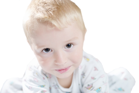 Funny cute little child in pyjamas with blonde hair isolatedの写真素材