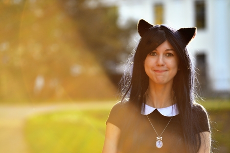 Cute girl with toy cat ears on head in sunbeam lightの写真素材