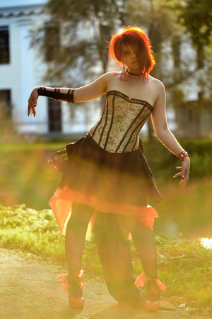 Portrait of beautiful red-hair woman on the natural background in Victorian suitの写真素材