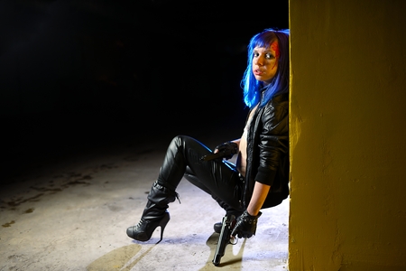 Sexy woman with blue hair holding two guns and looking as killerの写真素材