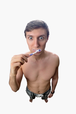 Funny man furiously brushing his teeth on white backgroundの写真素材