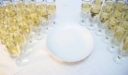 Glasses filled with wine stand in a rowの写真素材