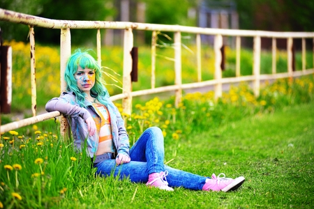 Portrait happy young girl on holi color festival about an old fenceの写真素材