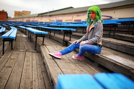 Beautiful young girl with bag posing football stadiumの写真素材