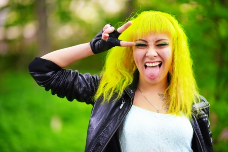 Beautiful hipster alternative young woman with yellow hair in parkの写真素材
