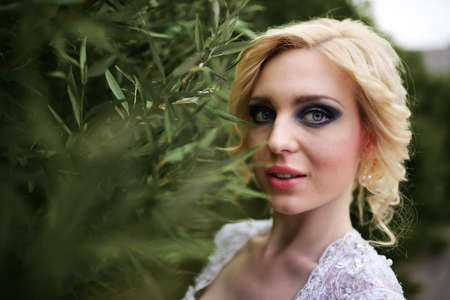 Portrait beautiful young bride in white dress in summer green parkの写真素材