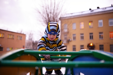 Small child plays at playground in winterの写真素材
