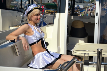 Beautiful sexy woman wearing sailor striped dress posing in boatの写真素材