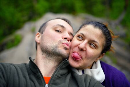Portrait of happy tourist couple taking selfie in forestの写真素材