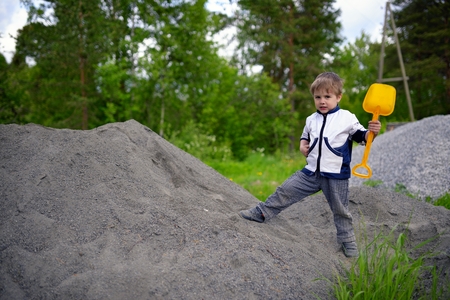 Little boy plays on heap of crushed stoneの写真素材