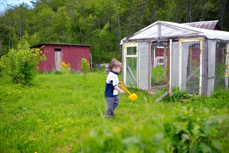 Little boy with toy shovel on courtyardの写真素材