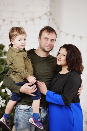 Happy family with against decorating Christmas treeの写真素材