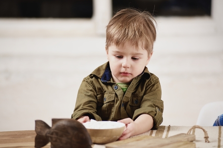 Little boy plays at a tableの写真素材