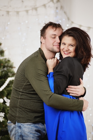 Young husband and wife laugh in Christmas decorate roomの写真素材