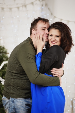Young husband and wife laugh in Christmas decorate roomの写真素材