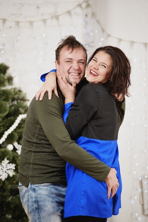 Young husband and wife laugh in Christmas decorate roomの写真素材