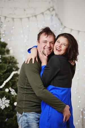 Young husband and wife laugh in Christmas decorate roomの写真素材