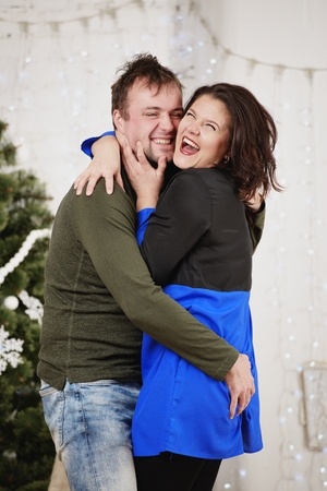 Young husband and wife laugh in Christmas decorate roomの写真素材
