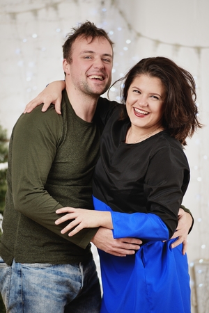 Young husband and wife laugh in Christmas decorate roomの写真素材