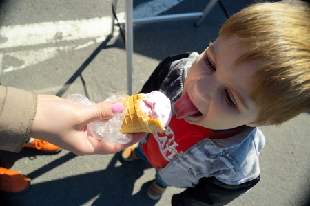 Mother feeds child with ice creamの写真素材