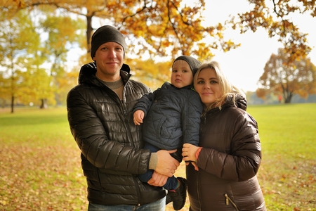 Happy family walking in autumn parkの写真素材
