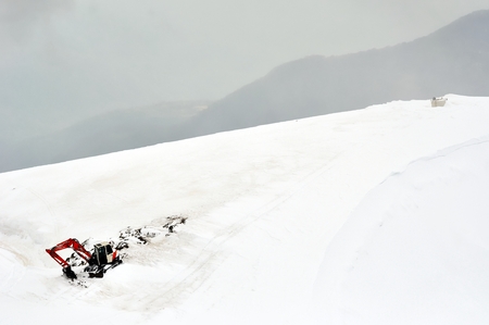 Winter mountain landscape with excavator on topの写真素材