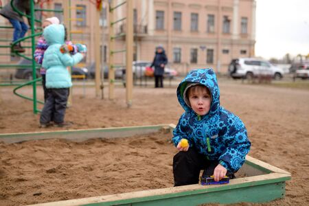 Little boy plays in a sandbox on playgroundの写真素材