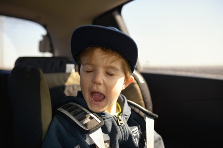 Cute little child sitting in safety car seatの写真素材