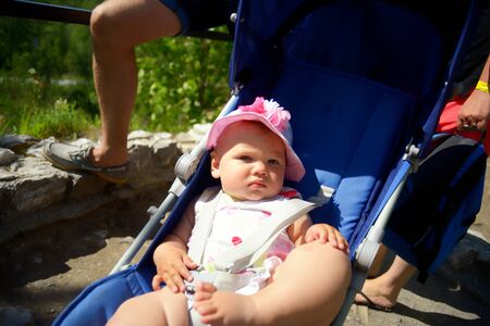 Baby in sitting stroller on natureの写真素材