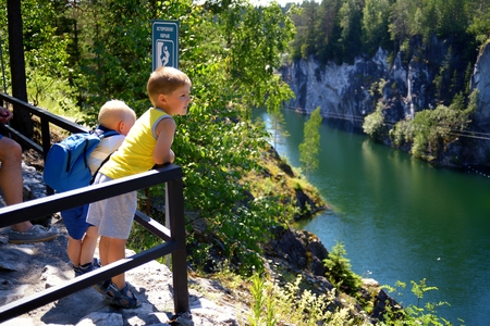 Two small childrens look through a handrail at a canyonの写真素材