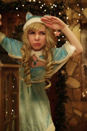 Snow Maiden holds lantern on doorstep of house decorated in Christmas styleの写真素材