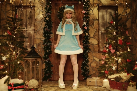 Snow Maiden on doorstep of house decorated in Christmas styleの写真素材