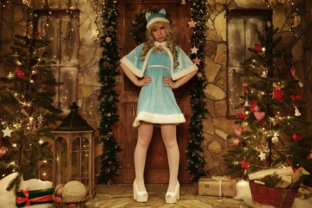 Snow Maiden on doorstep of house decorated in Christmas styleの写真素材