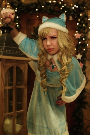 Snow Maiden holds lantern on doorstep of house decorated in Christmas styleの写真素材