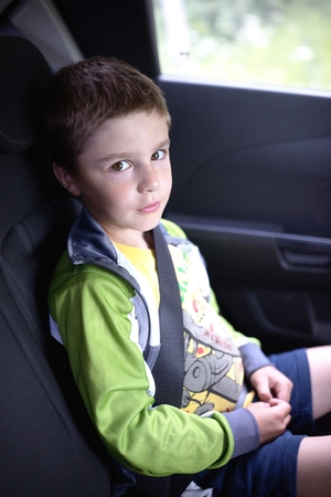 Boy sitting in car safety chairの写真素材
