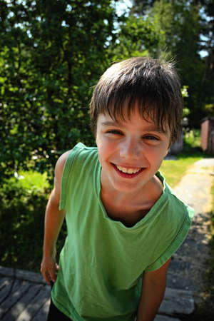 Closeup portrait cute little boy smiling in a parkの写真素材